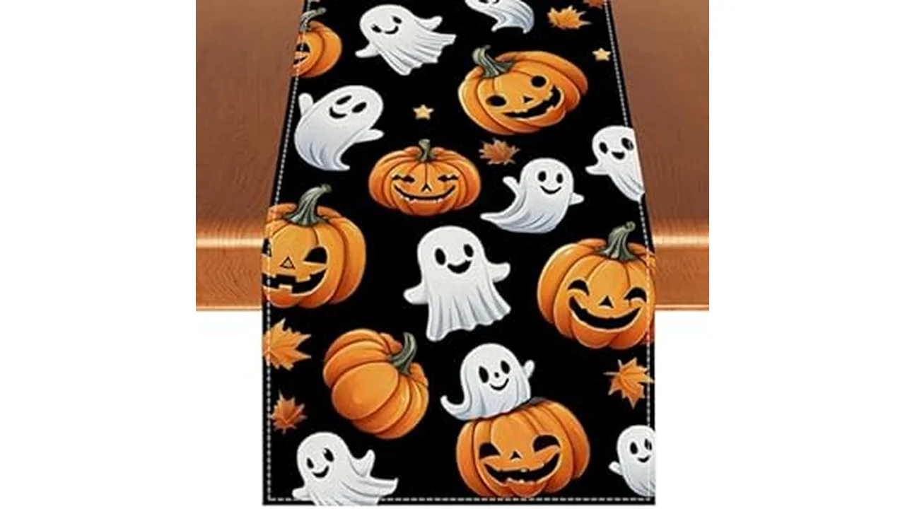 The image shows a festive Halloween table runner with pumpkins and leaves, ideal for seasonal decorating.